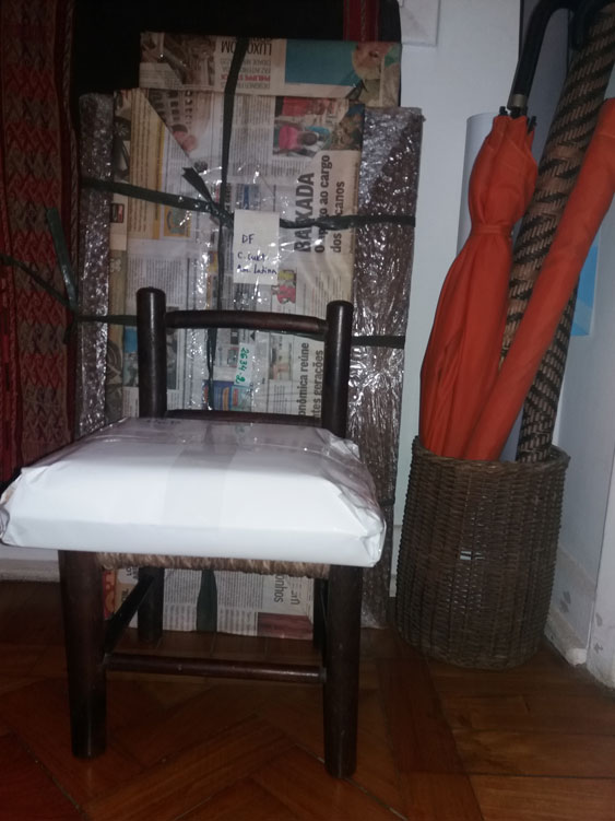 Na cadeira, pacote com publicações sobre Fayga e atrás, pacote com matrizes de xilogravura e gravura em metal.